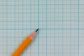 Simple graphite pencil on blank sheet of checkered notebook. School notebook with pencil on desktop Royalty Free Stock Photo