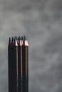 Simple graphite pencils on grey background. Black pencils, space for text Royalty Free Stock Photo