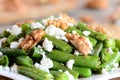 Simple green beans salad. Green beans warm salad with cottage cheese, crunchy walnuts, garlic and spices on a plate