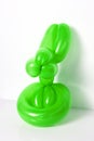 Simple green twisted balloon animal rabbit on white. Toy of balloons, bunny. Balloon art.
