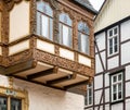 Simple half-timbered faÃÂ§ade in the background and richly carved half-timbered house on an oriel in the old town