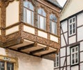 Simple half-timbered faÃÂ§ade in the background and richly carved half-timbered house on an oriel in the old town