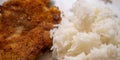 Simple home cooking for a bachelor from a breaded and pan-fried escalope of white boiled rice, simple dish