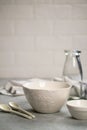 Simple home kitchen still life on a background of light walls on a gray concrete table. Set of Porcelain Dishes and glass bottle. Royalty Free Stock Photo