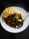 A simple home-made dinner delicious Asian food. It consists of white rice, chicken, stir-fried vegetables, and Krupuk. Royalty Free Stock Photo