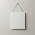 A simple image of a blank white square sign hung on a light gray wall. The sign is Royalty Free Stock Photo