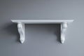 A simple interior design setting features a minimalist white shelf mounted on a light gray wall Royalty Free Stock Photo