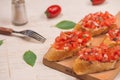 Simple italian appetizing bruschetta with tomato, on wooden table