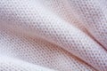 Simple knitted fabric made of pink yarn with large folds