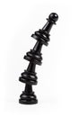 Simple leaning tower made of chess pawn pieces, curved bent construct of black game pieces standing on each other. Teamwork