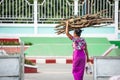 Simple life style at Tarchileik market, Eastern Myanmar. Women burmese in traditional clothing carrying a bundle of firewood on