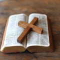 a simple light oak colored cross on a open bible .