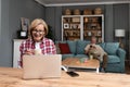 Simple living. Happy retired senior couple at their home spending time together. Enjoying in life surfing the internet on laptop, Royalty Free Stock Photo