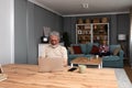 Simple living. Happy retired senior couple at their home spending time together. Enjoying in life surfing the internet on laptop, Royalty Free Stock Photo