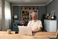 Simple living. Happy retired senior couple at their home spending time together. Enjoying in life surfing the internet on laptop, Royalty Free Stock Photo