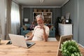 Simple living. Happy retired senior couple at their home spending time together. Enjoying in life surfing the internet on laptop, Royalty Free Stock Photo