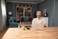 Simple living. Happy retired senior couple at their home spending time together. Enjoying in life surfing the internet on laptop, Royalty Free Stock Photo