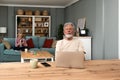 Simple living. Happy retired senior couple at their home spending time together. Enjoying in life surfing the internet on laptop, Royalty Free Stock Photo