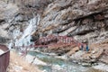 Simple metal bridge over a rough mountain river in the mountainous region Royalty Free Stock Photo