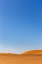 Simple minimalist desert landscape with golden sand dunes, low horizon, crystal blue sky, copy space, background