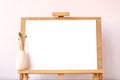 Blank white paper mockup for painting on wooden easel on table at home studio Royalty Free Stock Photo