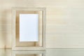 Simple mockup template with wooden vertical frame, white card on wooden background on mirror reflective surface Royalty Free Stock Photo