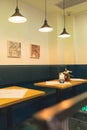 Simple modern design of Italian restaurant, green and yellow interior decor with wooden furniture
