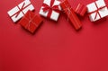 Simple, modern red & white Christmas gifts presents on red background. Festive holiday border. Royalty Free Stock Photo