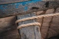 Simple natural rope tied around wooden part of fishing boat, closeup detail Royalty Free Stock Photo