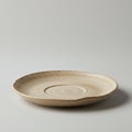 A simple, neutral-toned ceramic plate with a slightly irregular shape sits on a plain Royalty Free Stock Photo