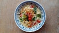 Simple noodle soup with the addition of tomatoes and mustard greens and a sprinkling of chili powder and fried shallots.