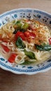 Simple noodle soup with the addition of tomatoes and mustard greens and a sprinkling of chili powder and fried shallots.