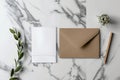 A simple notepad with a pen and envelope placed on a smooth marble surface, ideal for writing letters or making notes Royalty Free Stock Photo