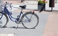 A simple one single old bike parked on the street sidewalk, detail, closeup, nobody, shopping bags. Eco green city transportation