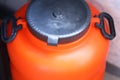 A simple orange plastic container with a black lid Royalty Free Stock Photo