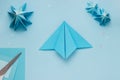 Simple origami 3D Christmas tree made from blue paper. Step by step instruction, step 8