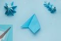 Simple origami 3D Christmas tree made from blue paper. Step by step instruction, step 14