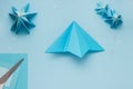 Simple origami 3D Christmas tree made from blue paper. Step by step instruction, step 9