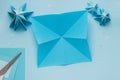 Simple origami 3D Christmas tree made from blue paper. Step by step instruction, step 6