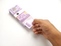 Simple Photo Conceptual, Top View Caucassian Right Man Hand Picking one sheet 10000 Rupiah Indonesia Paper Money at white