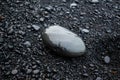 Simple picture of a pebble on black sand beach. Wellness, calm, peaceful concept. Great for wall art canvas picture. Royalty Free Stock Photo