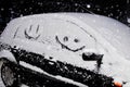 simple picture of a smile carved in the snow upon a window of a black car, Happy life of winter Royalty Free Stock Photo