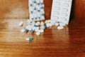 Simple pile of white and blue pills, medicines, pills stacked on brown background Royalty Free Stock Photo