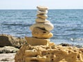 Simple poise pebbles stack, rock zen sculpture, a stone tower. Beach sand stone zen cairn. A stone pyramid on sea shore Royalty Free Stock Photo