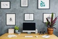 Simple posters hanging on grey raw wall in study corner living r Royalty Free Stock Photo