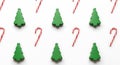Simple repeating pattern of small pine trees and red candy canes. Royalty Free Stock Photo