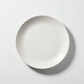 A simple, round, white ceramic plate is centered on a white background. The plate has Royalty Free Stock Photo