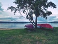 Simple rowing boat stacked at lake upside down. Empty beach