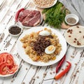 Simple Rustic food plate. Rice with meat, tomato salad and hot chili pepper on wooden kitchen table. Ingredients for Royalty Free Stock Photo