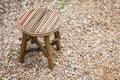 Simple rustic wooden chair. Retro stool on break stones.